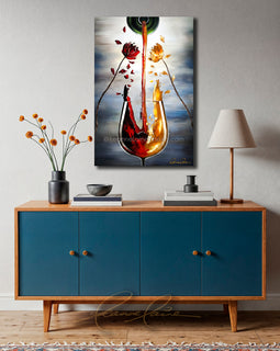 Blue cabinet with wooden top featuring am abstract wine art painting of a wine glass with red and yellow flower petals falling from flowers into the glass on a gray wall.