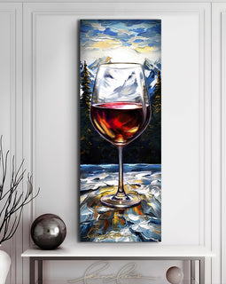 Painting of a glass of wine outdoors against a snow covered mountain landscape displayed above a modern table with vase